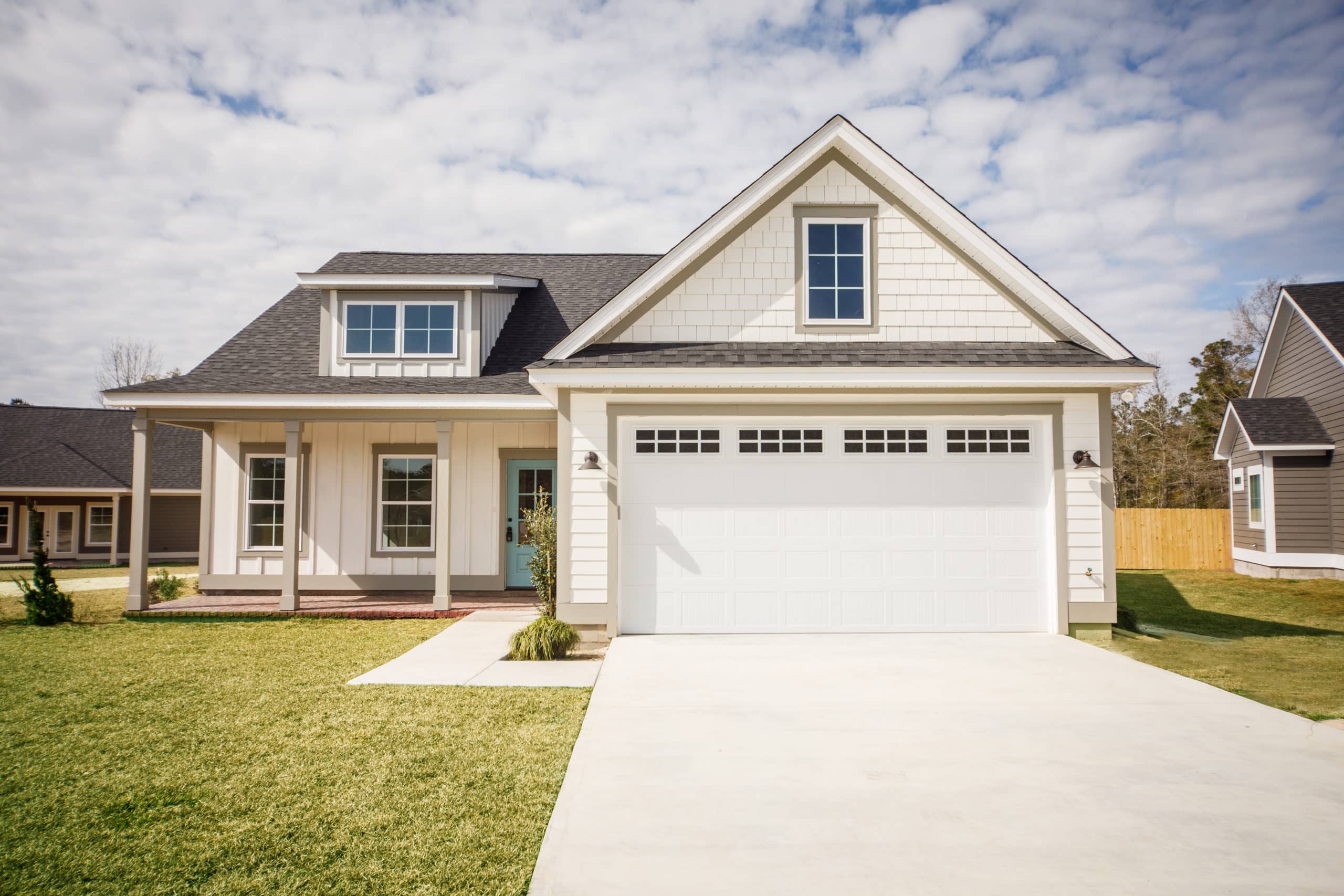 Modern new Construction White Siding Cottage House for Sale in Suburbs with Turquoise Door protected by Radon Crew mitigation system