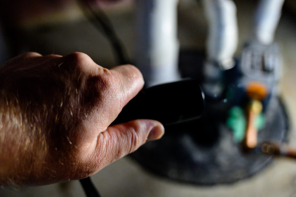 flashlight shining light on sump pump system